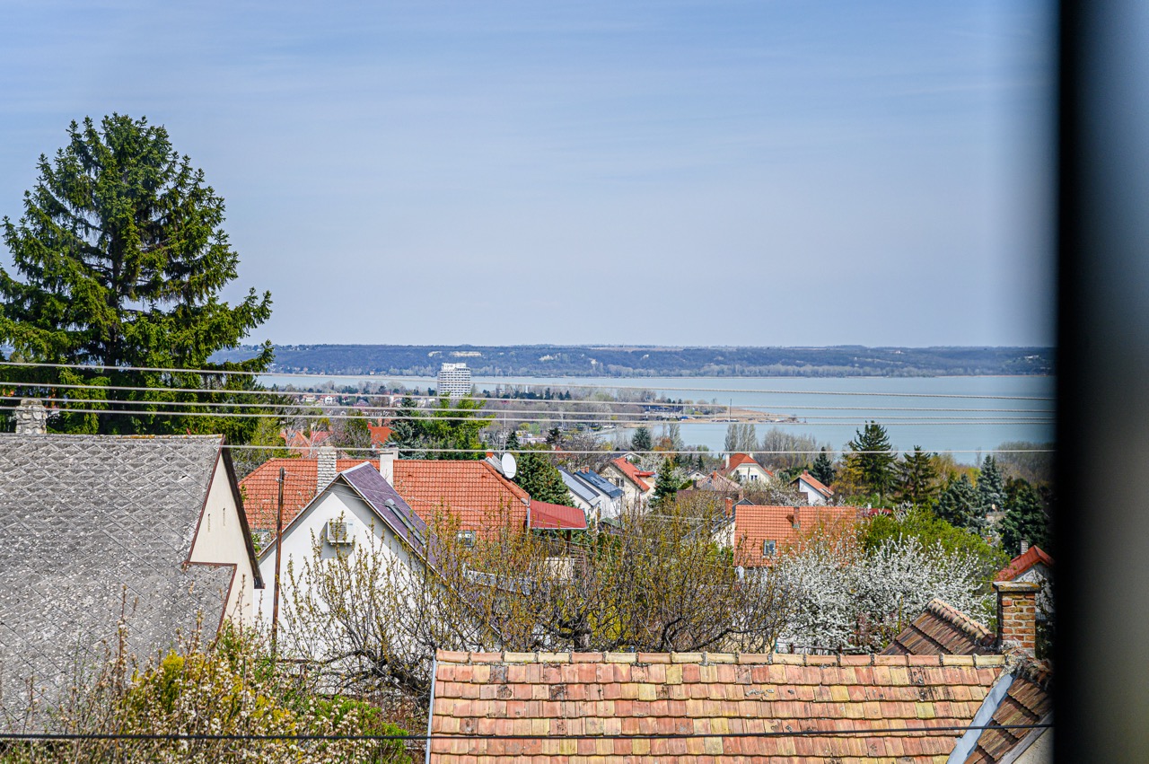 Panorámás kilátás lakóövezetre, háttérben a Balatonnal és tiszta égbolttal